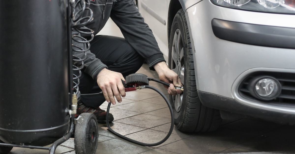 person adding air to car tire - rocket car maintenance