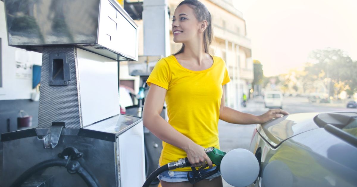 woman in yellow shirt pumping gas into vehicle - rocket chip engine tuning