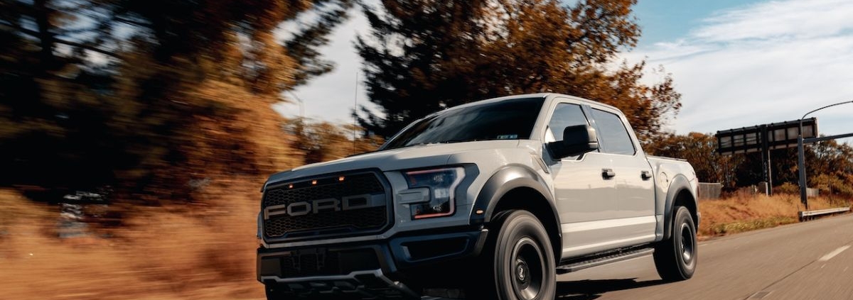 white Ford truck driving on a country road - rocket chip performance chips