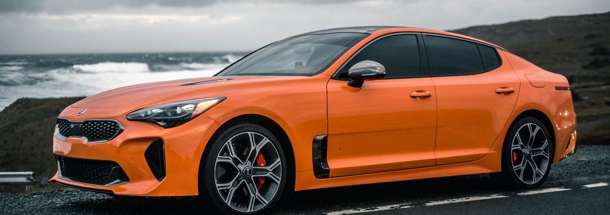 bright orange Kia car driving on gloomy day - rocket chip Performance Chips