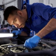 male mechanic working under the hood of a car - rocket chip plug in Performance Chips