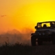 Jeep Wrangler driving through grass during sunset - rocket chip Jeep performance chips