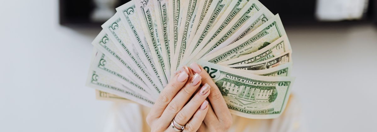 woman holding up a fan of USD paper currency - rocket chip ECU tuning chip