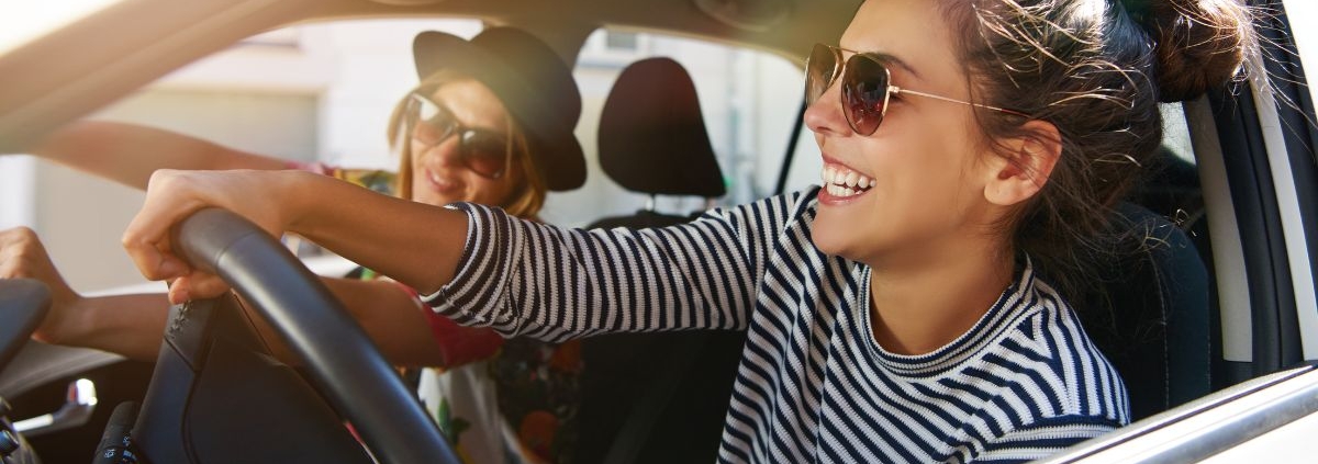 two woman driving in vehicle together while smiling - rocket chip plug in performance chip