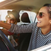 two woman driving in vehicle together while smiling - rocket chip plug in performance chip