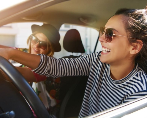two woman driving in vehicle together while smiling - rocket chip plug in performance chip