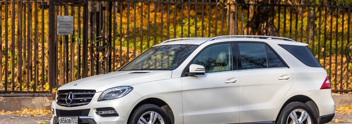 white Mercedes SUV parked near a black fence - rocket chip plug in performance chip