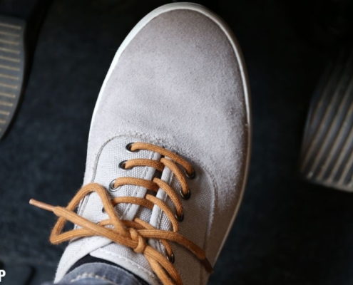 foot wearing a gray shoe pressing the gas pedal - rocket chip plug in performance chip