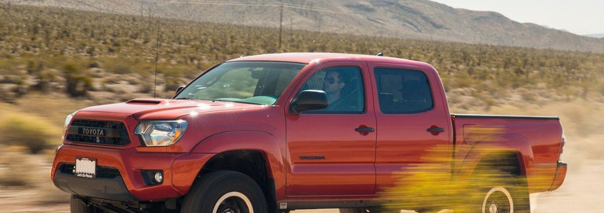 red Toyota truck driving through dirt road - rocket chip Toyota performance chips