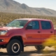 red Toyota truck driving through dirt road - rocket chip Toyota performance chips
