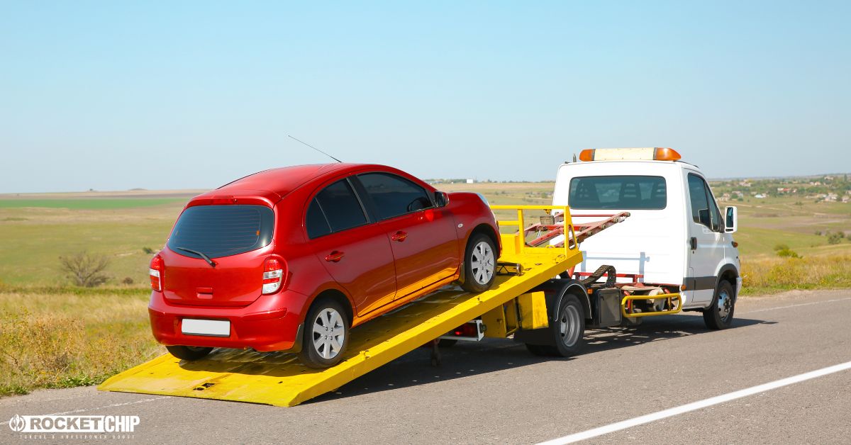 tow truck with a yellow bed hauling a red car - rocket chip Increasing Power for Towing