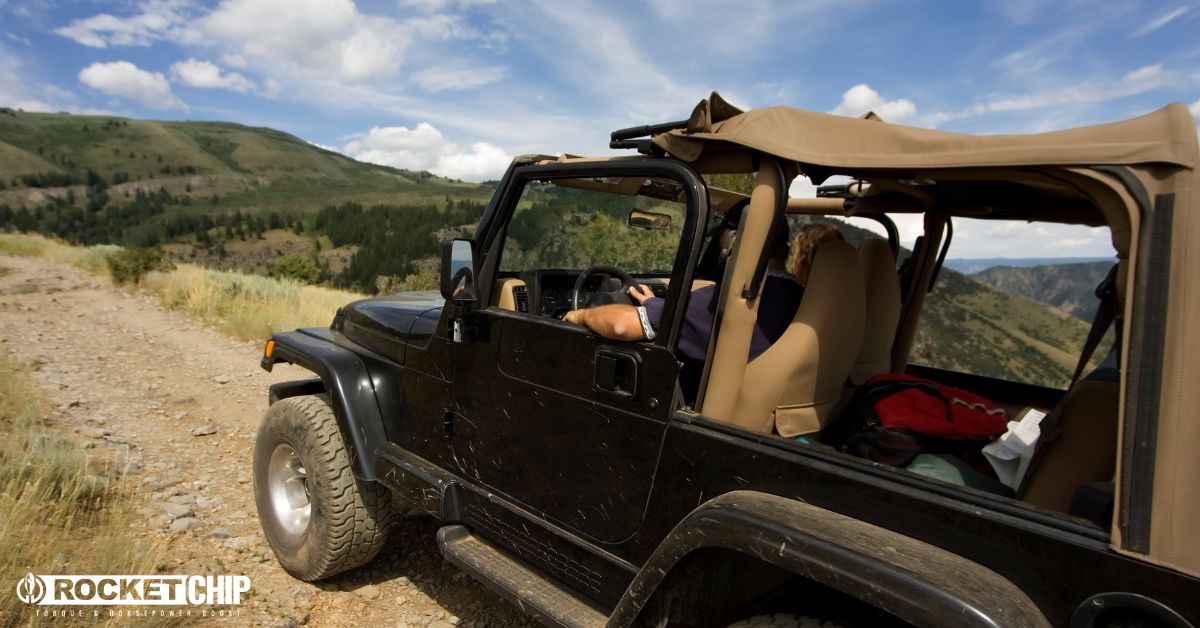 side view of a person driving a black Jeep Wrangler - rocket chip Jeep Performance Chips