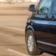 close up of a black mini van driving on a road - rocket chip improving MPG