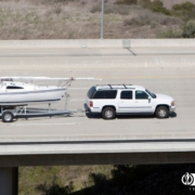 large white SUV towing a white boat on the highway - rocket chip Increasing Power for Towing