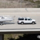 large white SUV towing a white boat on the highway - rocket chip Increasing Power for Towing