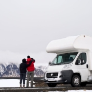 couple observing winter scene by their RV - rocket chip vehicle maintenance