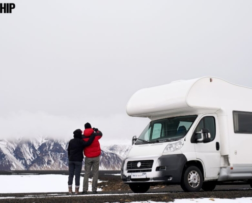 couple observing winter scene by their RV - rocket chip vehicle maintenance